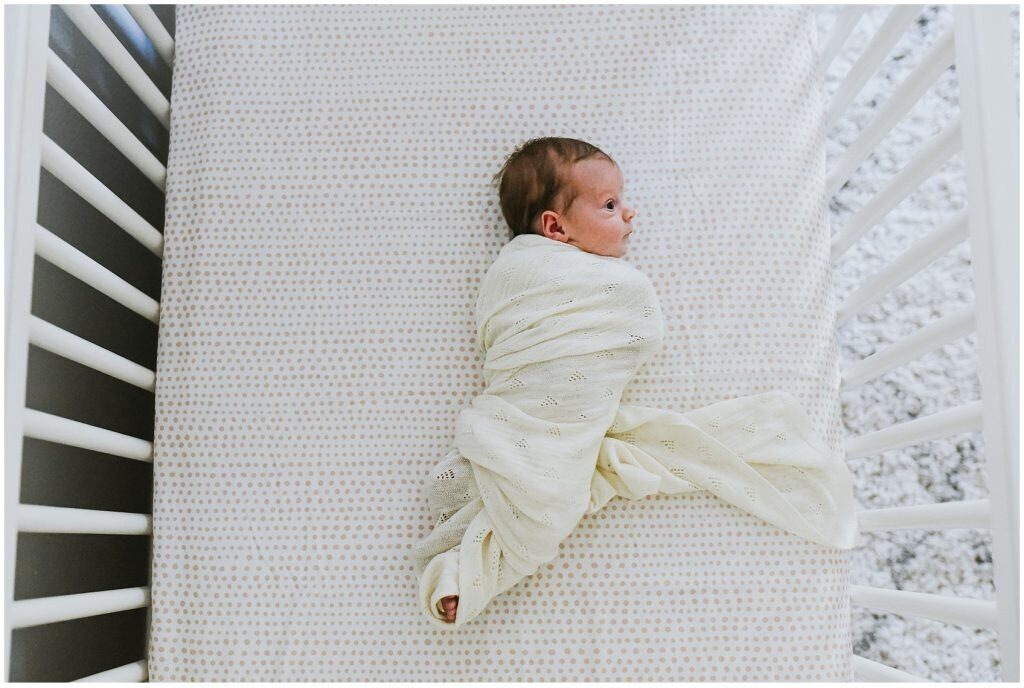 newborn baby in crib at home