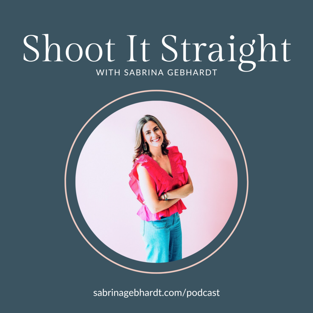 shoot it straight podcast host sabrina gebhardt stands against a pink wall