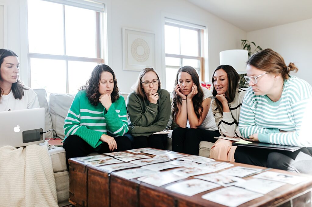 female photographers reviewing portfolios together at a photography mastermind retreat in seattle washington