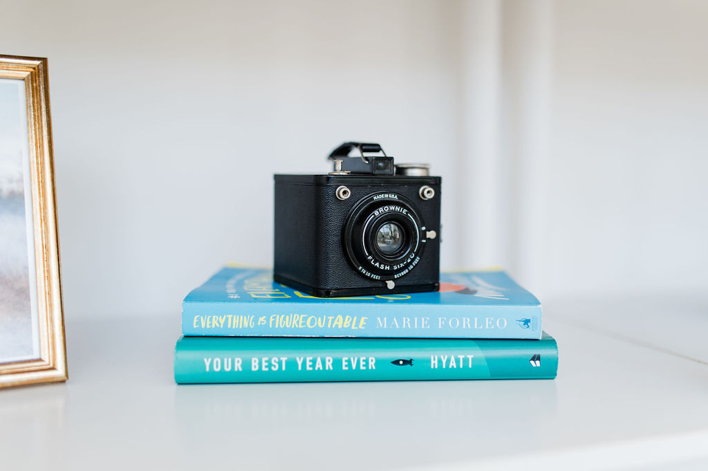 a camera on top of books topics like how to get photography clients