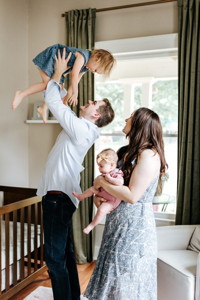 Photographer FAQ: "Can You Just Photograph the Kids?" (Here's My Take) 1 Playful moment of parents with two daughters in their home, a beautiful example supporting the photographer FAQ on capturing full family stories.