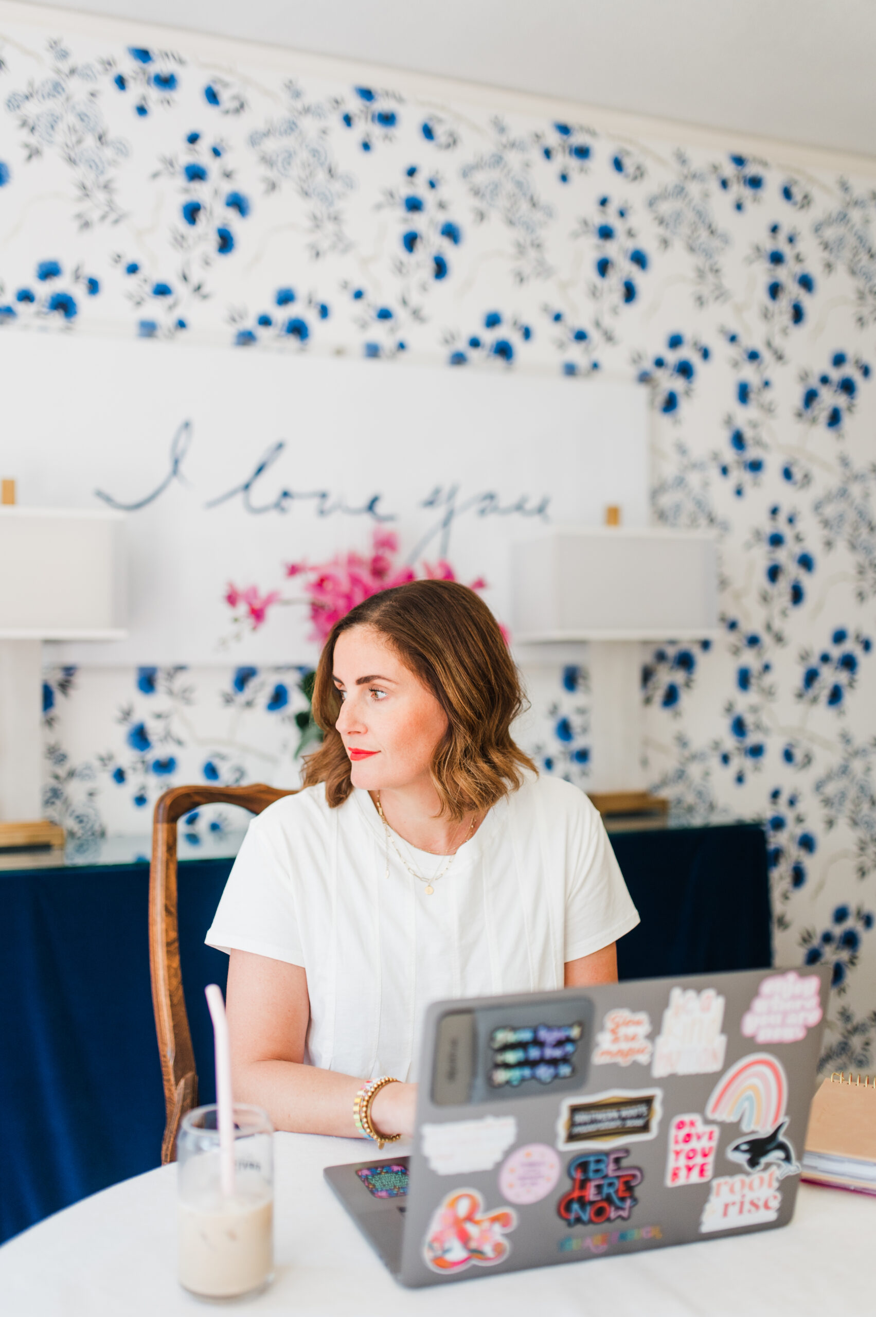 Photographer and business coach working at her laptop, sharing an honest Imagen AI review and how it saves hours of editing time.