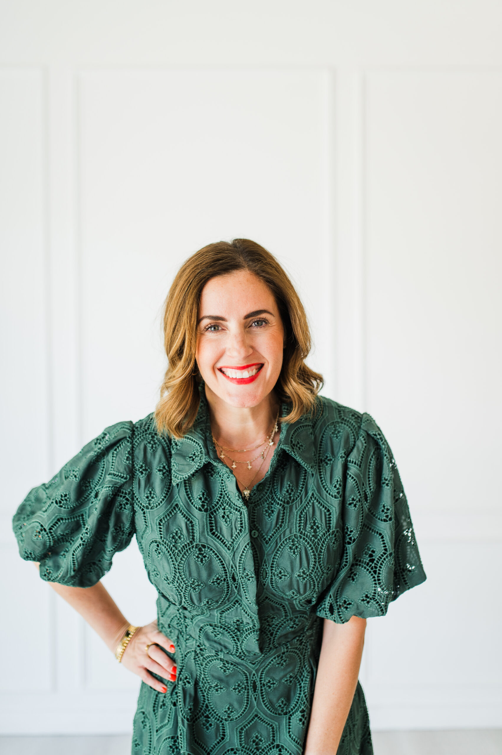 Mentor and coach Sabrina Gebhardt confidently standing in a green dress, helping creative business owners know when to raise your prices.