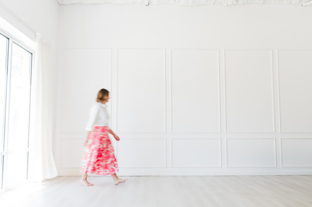Raise Your Prices With Confidence: How to Know When It’s Time (and Do It Without Guilt) 2 Blurry motion shot of Sabrina Gebhardt walking barefoot in a bright white studio, symbolizing freedom and alignment when you raise your prices.