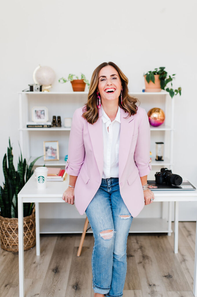 Photographer smiling in a bright home office, reflecting confidence gained by answering real photography questions.