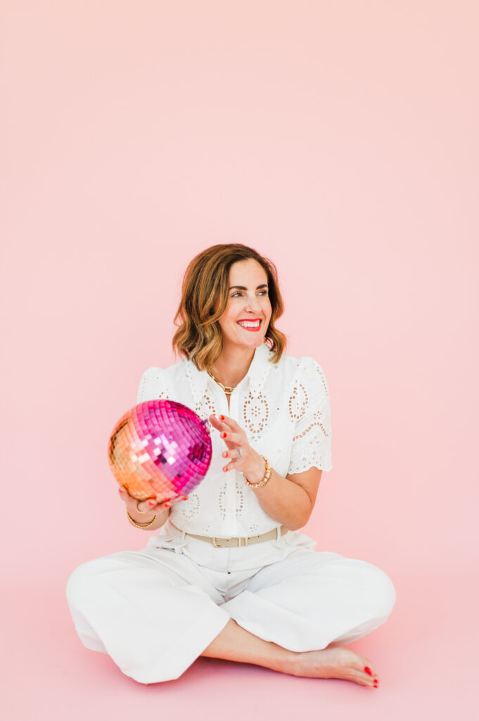Playful studio portrait of a photographer holding a disco ball, celebrating fun and creativity in photography.