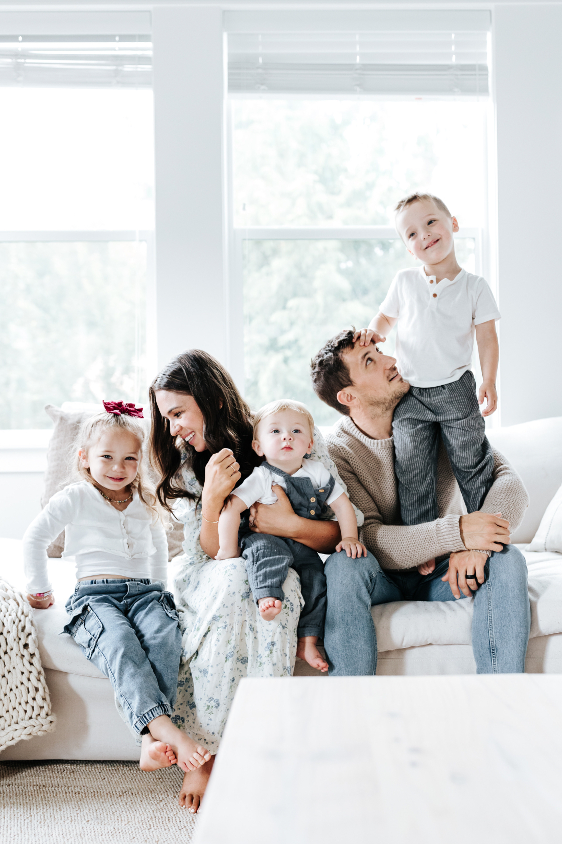 Family sitting together on a bright couch during an in home session, showing how preparing for a family photo session helps create relaxed and connected moments.