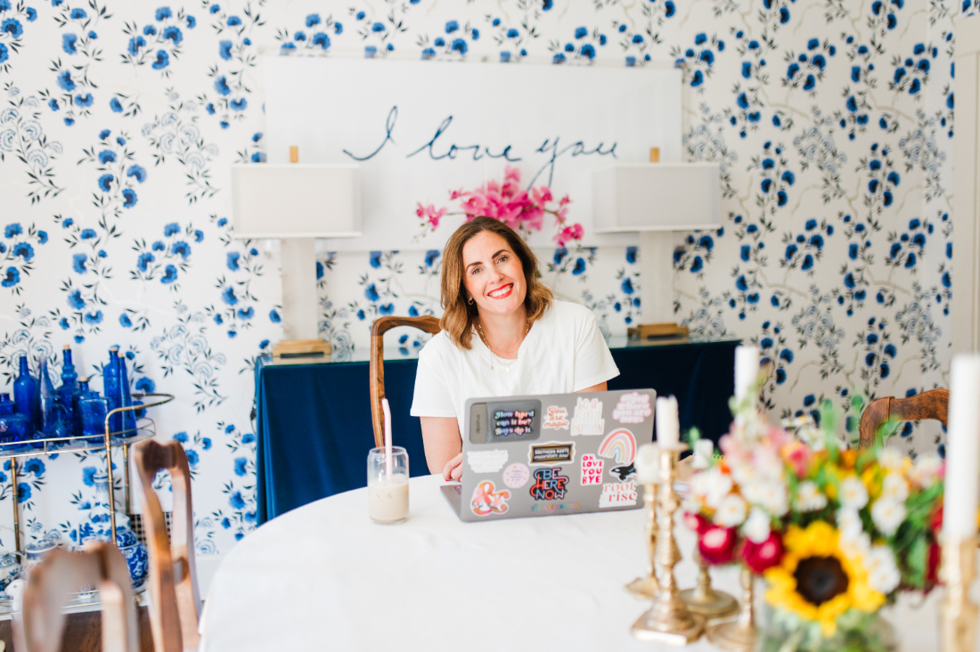 Sabrina Gebhardt working on her laptop while exploring what is Flodesk Studio and how it can simplify photography marketing.